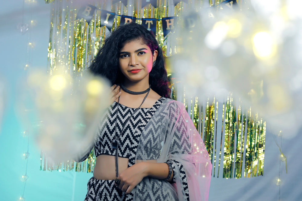 Photo of bride in a grey lehenga twirling with open hair with jewellery